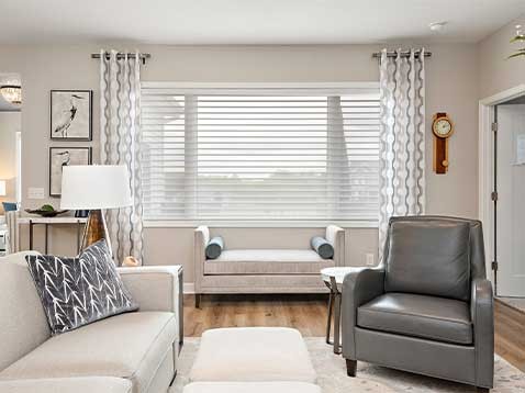Modern living room showcasing hanging blinds and drapery