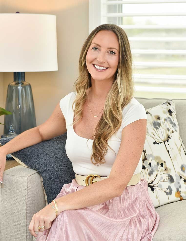 A smiling woman sitting on a couch posing for a photo